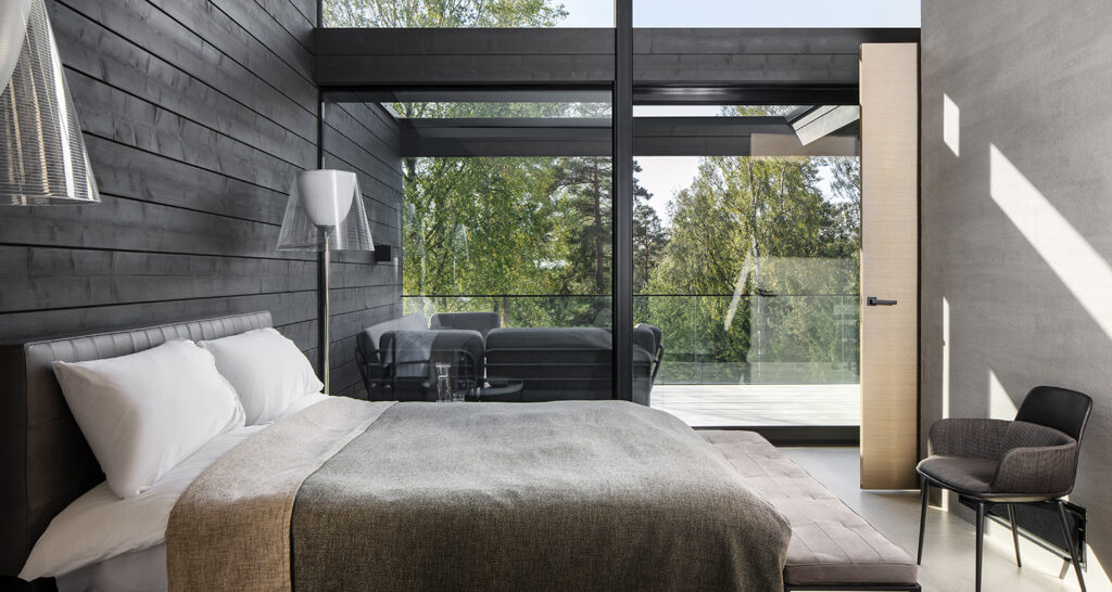 Bedroom with glass wall in modern Villa Cubic log house.